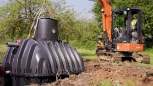 Image of a machine being used to lower a sewage treatment plant into a hole in the ground.