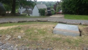 A new borehole manhole installed in a customer garden with a mini digger in the background