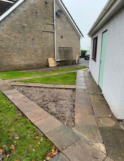 A photo of a garden showing paving slabs and grassed lawn where a sewage treatment plant is installed