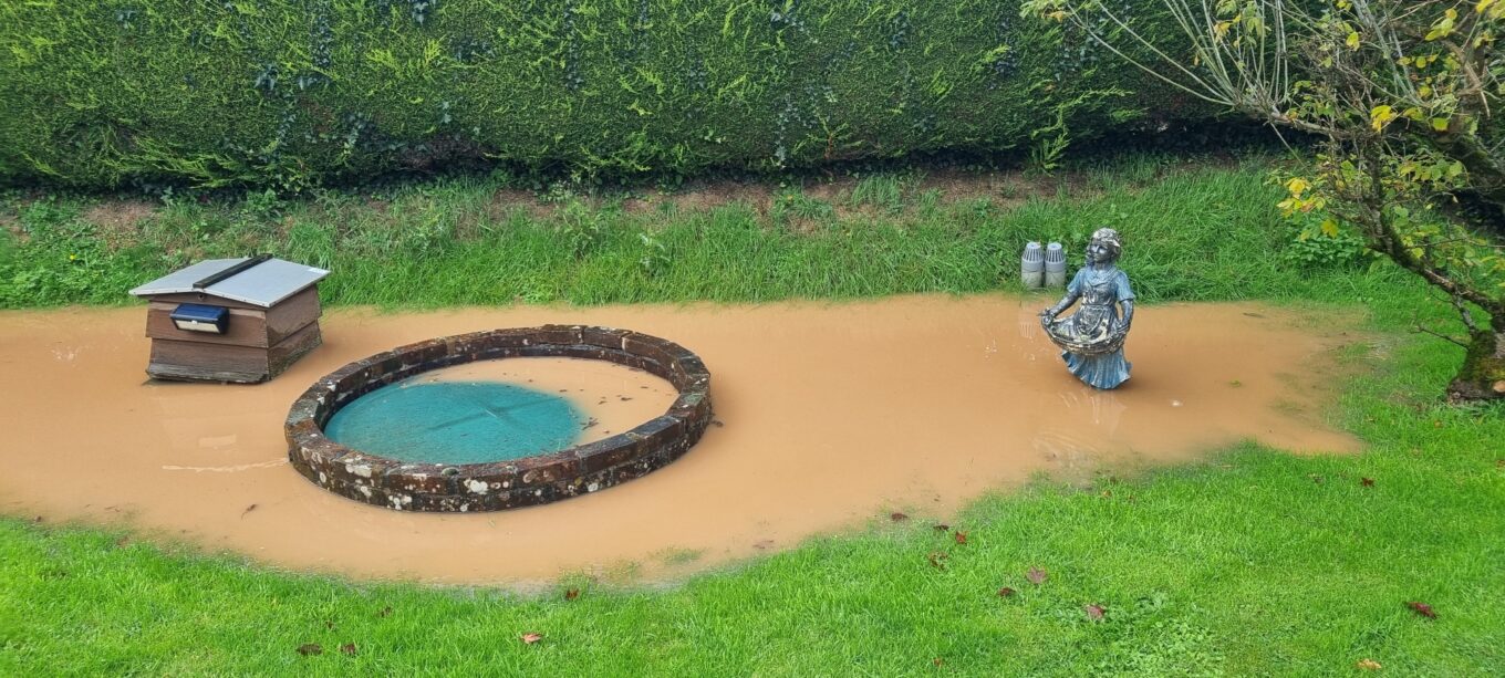 A sewage treatment plant under water in a flooded area of a garden