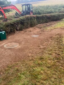 A newly installed sewage treatment plant along a hedge line in the garden of a rural property