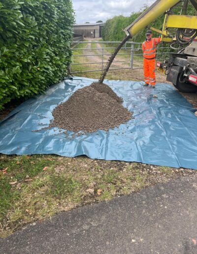 Concrete being emptied from a lorry onto a tarpaulin in a gateway